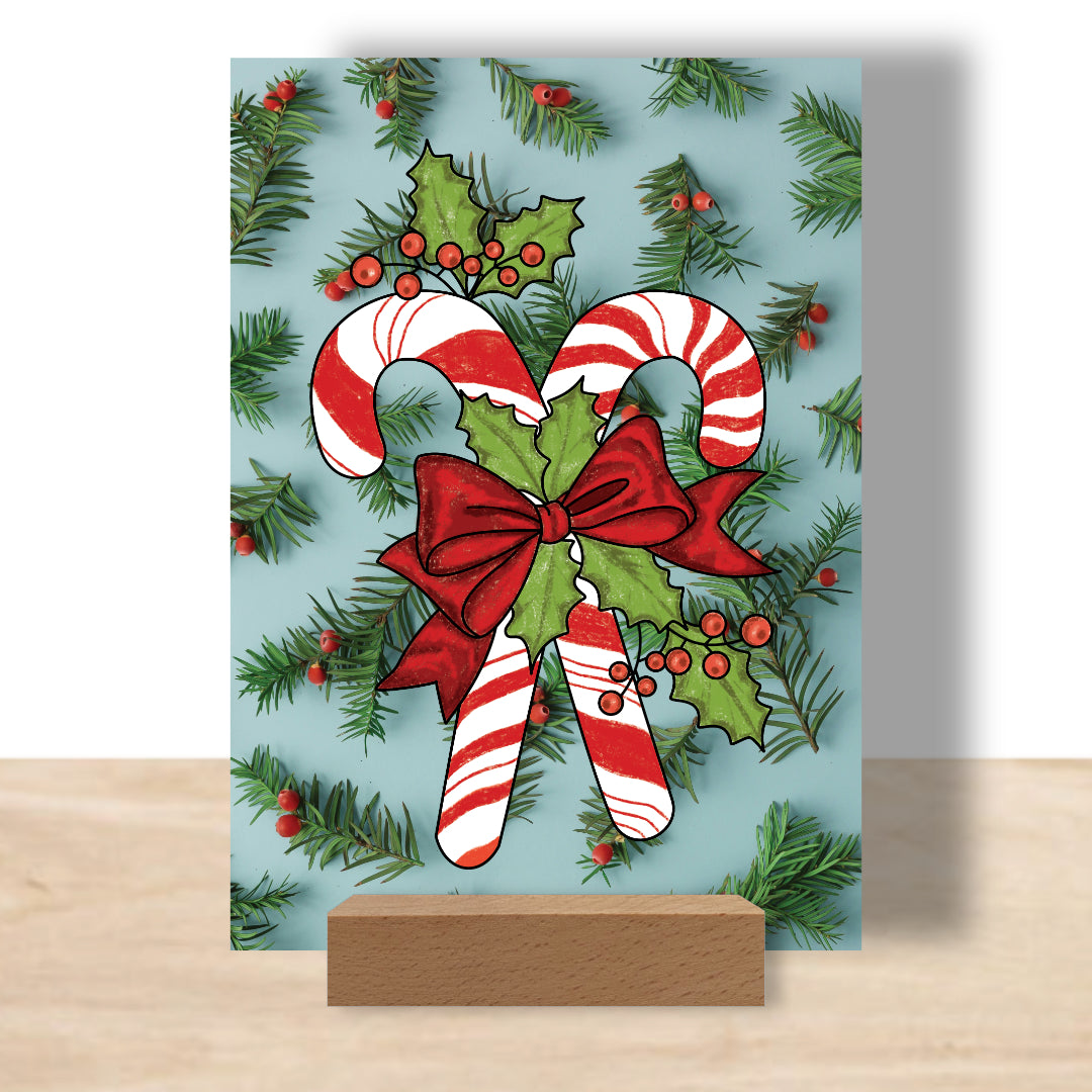 Postkarte mit ausgemalten Zuckerstangenmotiv als Beispiel. Aufgestellt auf einem Bilderhalter. Die sinnvolle Alternative zum Malbuch.