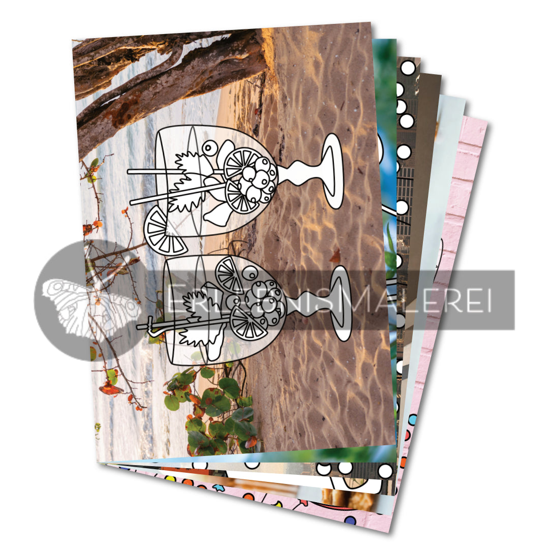 Malbuch aus Einzelseiten mit fröhlichen Motiven – vorne eine Ausmalkarte mit zwei bunten Cocktails am Strand vor tropischem Fotohintergrund; dahinter weitere lebensfrohe Motive aus dem Gute-Laune-Set von ErlebnisMalerei.