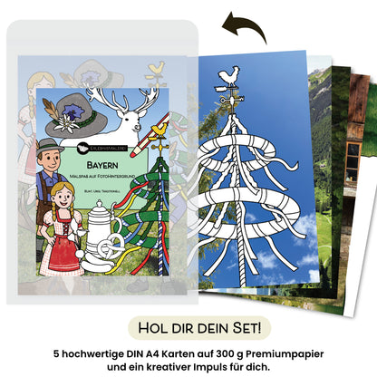 Ein Produktfoto des Malkarten Sets „Bayern“ von ErlebnisMalerei, einem traditionellen Malbuch in Kartenform. Die Titelkarte zeigt bayerische Motive wie ein Paar in Tracht, einen Hirschkopf, einen Hut und einen Maßkrug. Rechts daneben sind die fünf DIN A4 Malkarten aufgefächert sichtbar, mit ländlichen Fotohintergründen und schwarzweißen Ausmalmotiven wie einem Maibaum. Darunter steht „Hol dir dein Set!“ mit dem Hinweis auf hochwertiges Papier und kreativen Impuls.