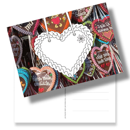 Postkarte mit Lebkuchenherz zum Ausmalen auf Lebkuchenherz-Fotohintergrund. Ein liebevoller Gruß aus Bayern.