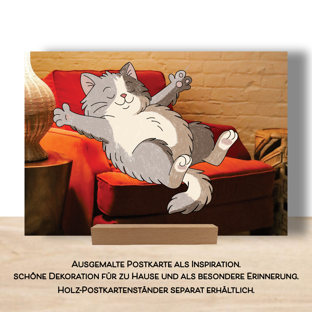 Ausgemalte Postkarte mit dem Motiv einer Katze in einem großen roten Sessel. Die Postkarte ist aus dem Postkarten Set "Smile". Aufgestellt im Postkartenständer als schönes Dekoelement. Ausgemalte Postkarten finden so ihren würdigen Platz.