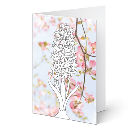 Grußkarte aus dem Ausmalset "Frühlingsgrüße" zum Ausmalen auf Fotohintergrund. Detaillierte Hyazinthe als Ausmalvorlage vor einem zarten Hintergrund aus rosa Kirschblüten.